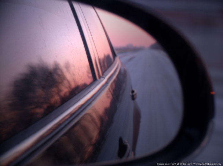 Rear mirror of a traveling car along the lonely country road in the evening, north east of China